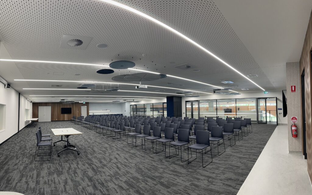 Function room with windows along the back wall and chairs set theatre style for a presentation