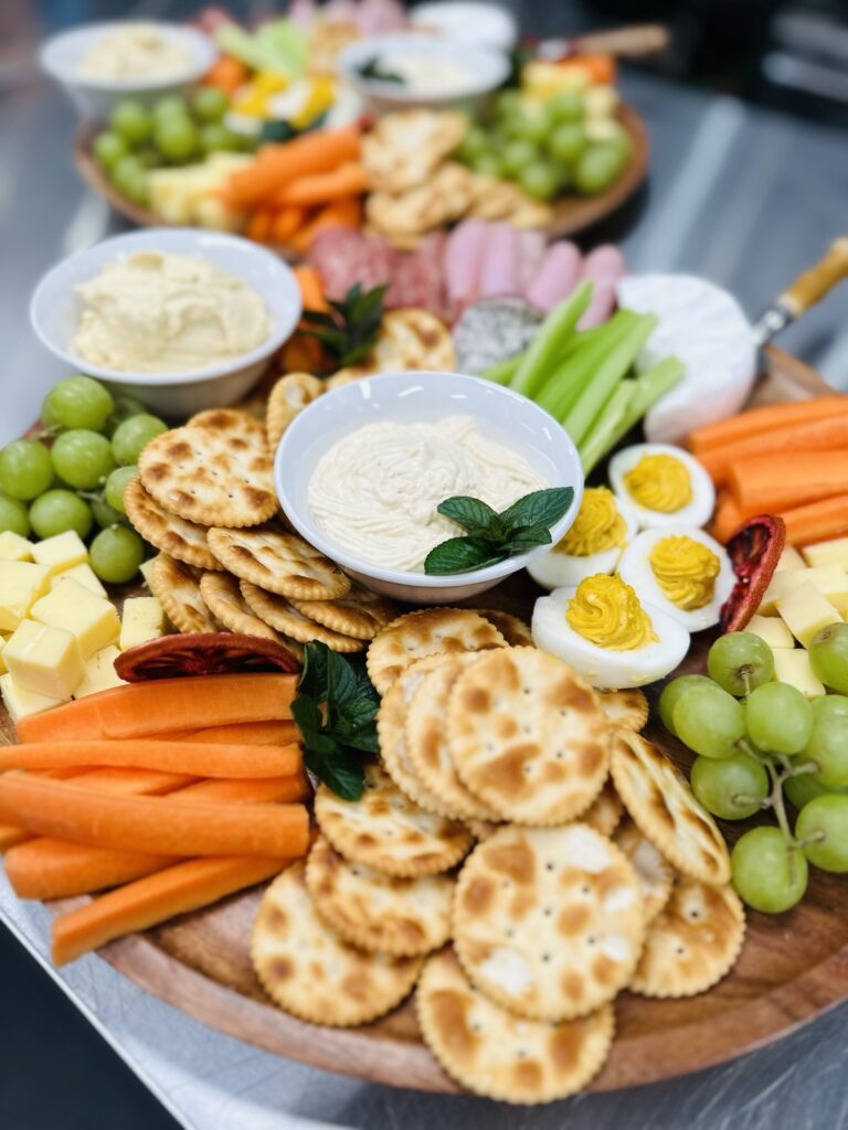 Platter with crackers, dips, carrots, grapes, eggs and deli meat