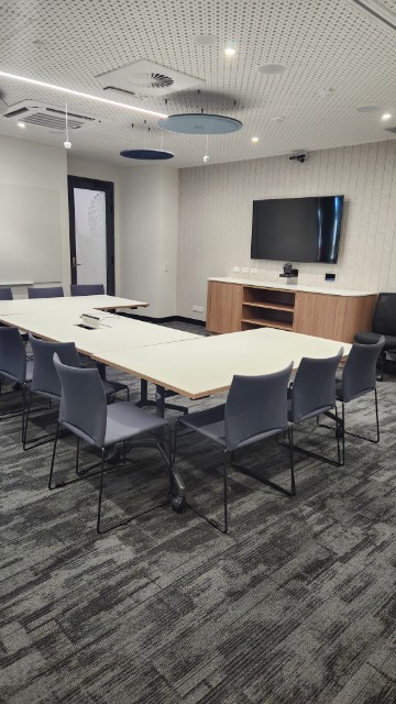 Meeting room with television, whiteboard and u-shaped seating