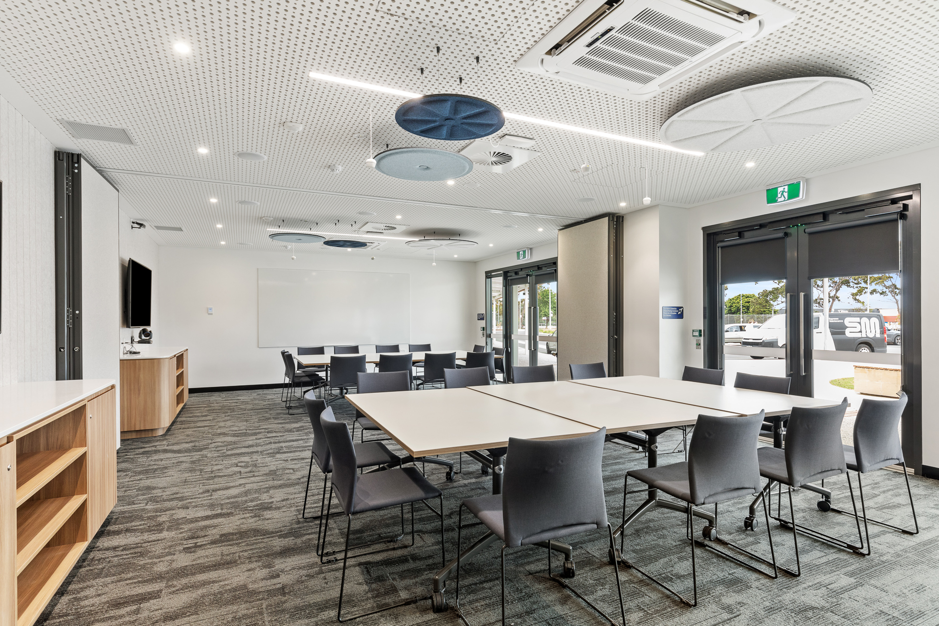 Meeting room with TV on wall and tables set in boardroom style